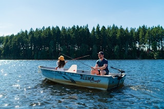 A man and woman enjoy fishing from a small boat on Offut Lake